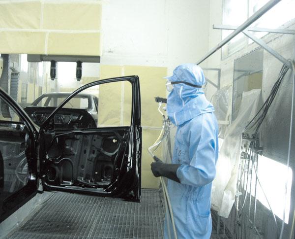 汽車(chē)涂裝車(chē)間生產(chǎn)工人穿著防靜電連體服正在工作
